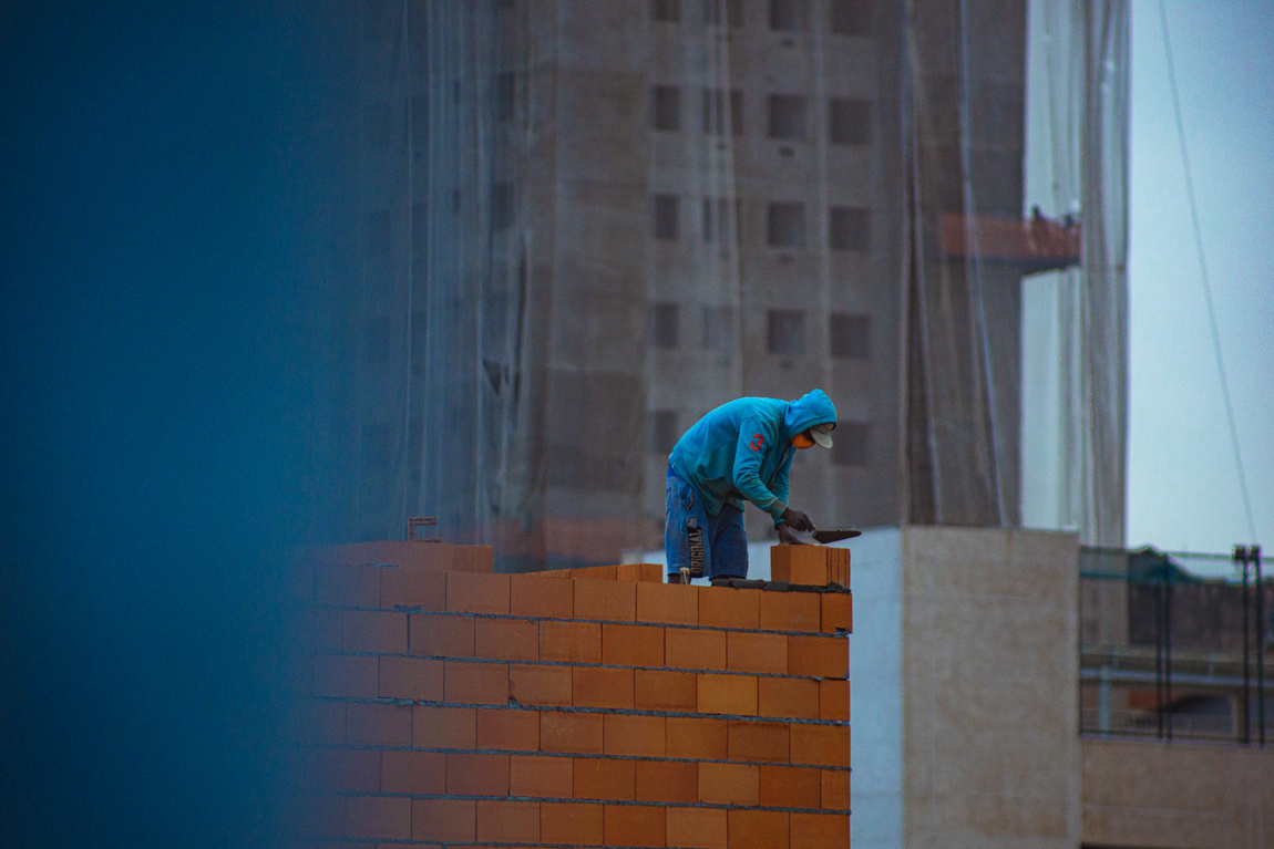 Faceless male builder working on construction site
